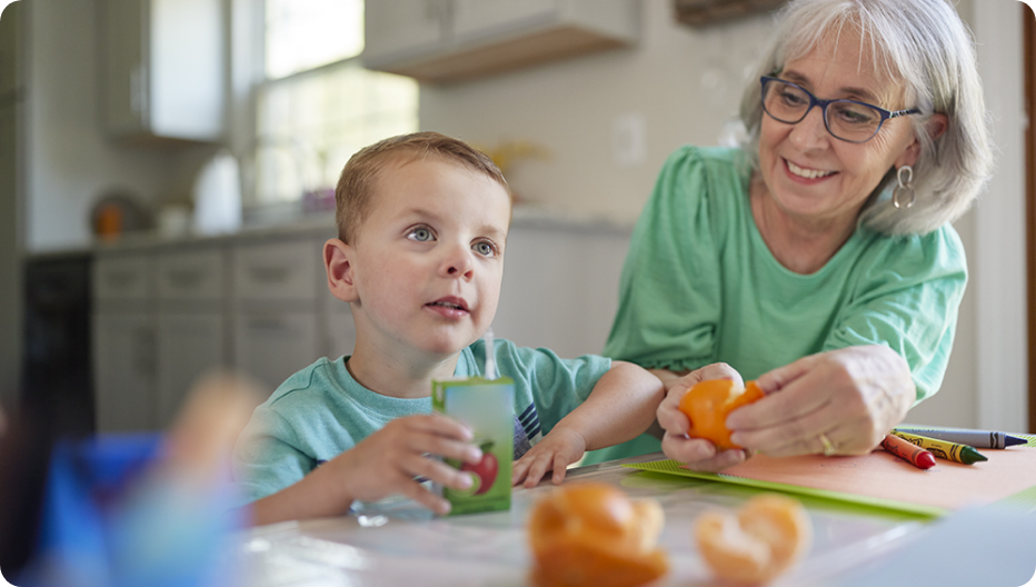 Roland at a table with his grandmother having a snack